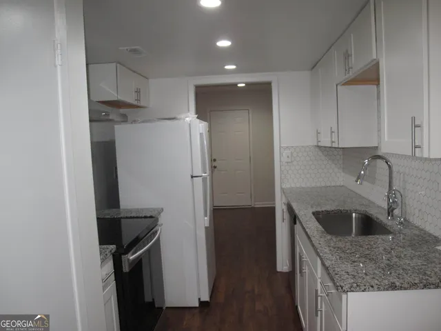 a kitchen with a refrigerator sink and cabinets