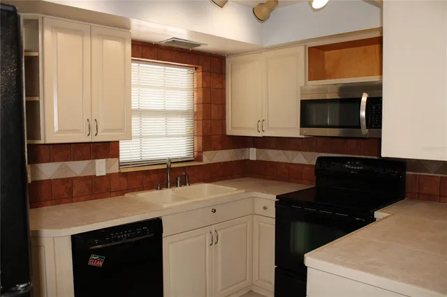 a kitchen with a sink stove and microwave