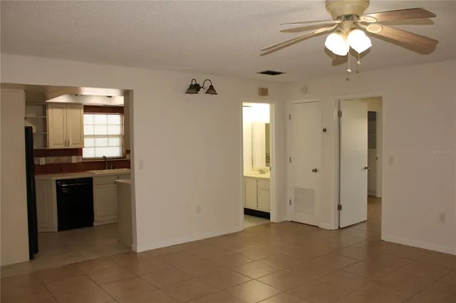 a view of an empty room with a kitchen