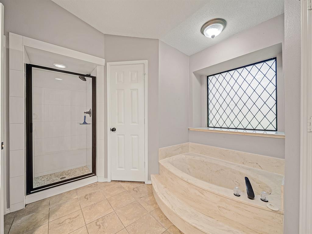 121 Northeast Brushy Mound Road Burleson, TX 76028 - Photo 30 of 35 a white bath tub sitting in a bathroom