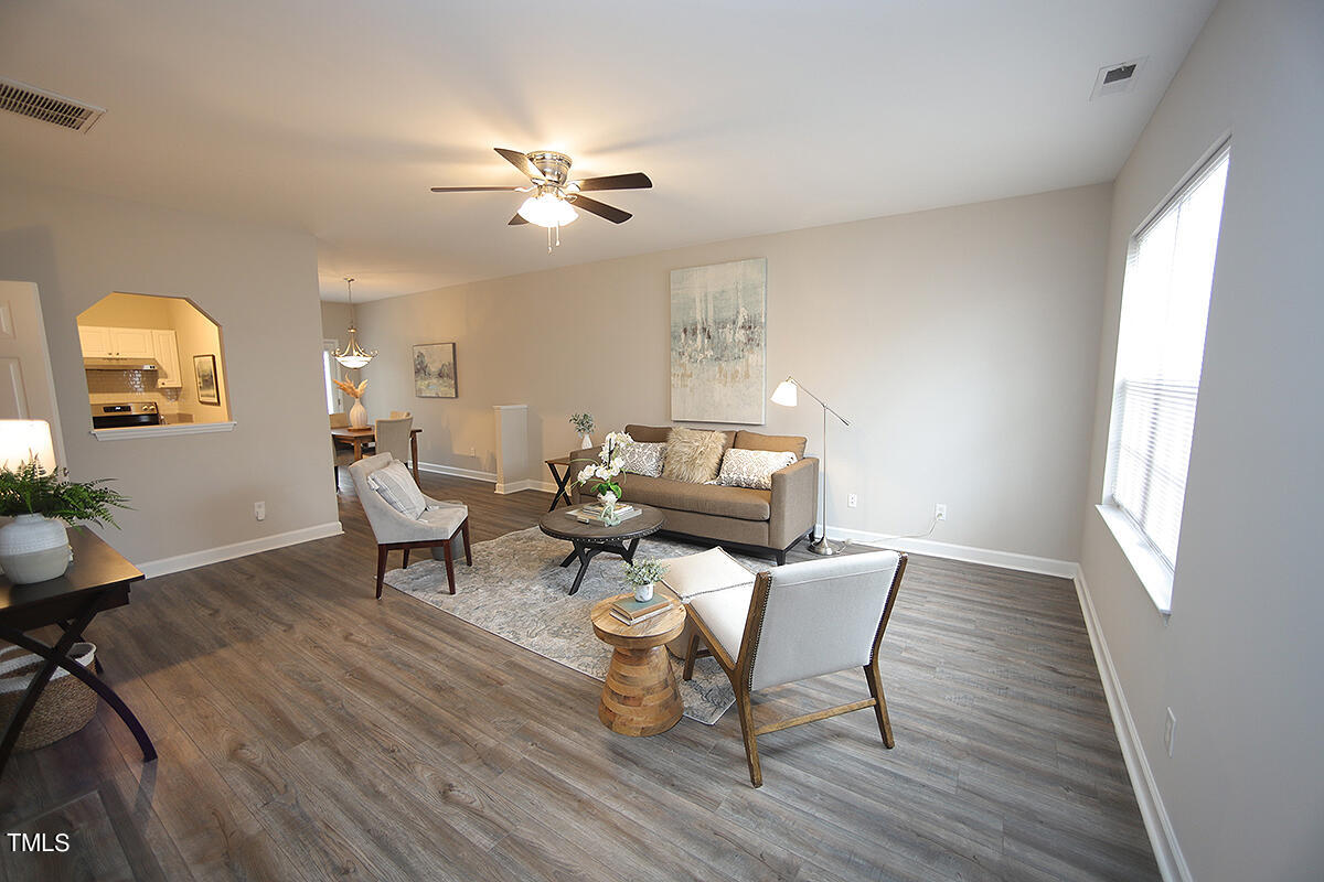 a living room with furniture and a wooden floor