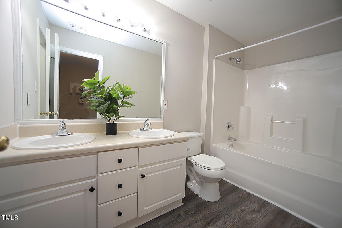 6012 San Marcos Way Raleigh, NC 27616 - Photo 12 of 17 a bathroom with a double vanity sink toilet mirror and shower