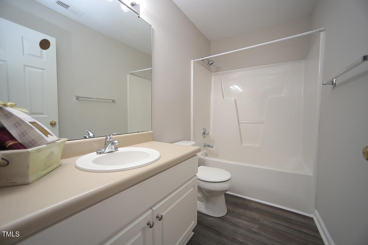 6012 San Marcos Way Raleigh, NC 27616 - Photo 15 of 17 a bathroom with a sink toilet a mirror and shower
