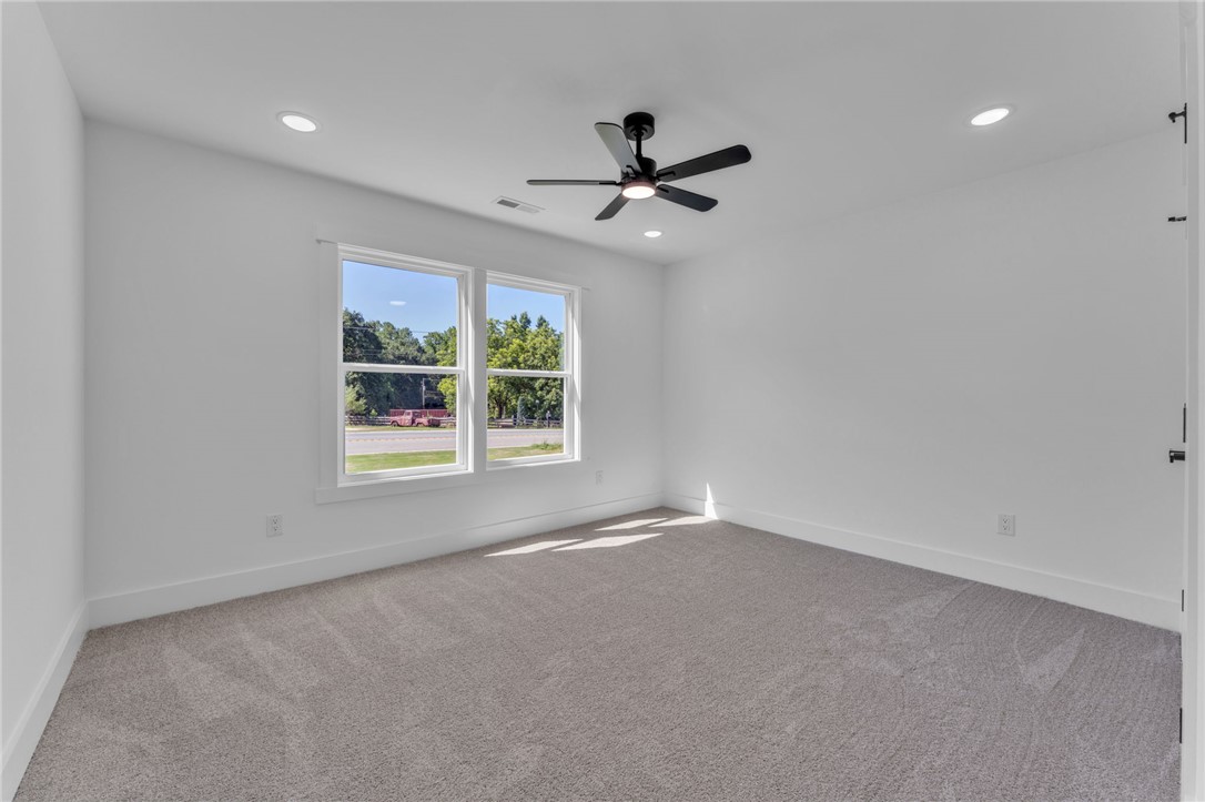 1723 Harris Bridge Road Anderson, SC 29621 - Photo 19 of 33 A quiet bedroom with ample natural light, featuring plush carpeting and modern ceiling fixtures.
