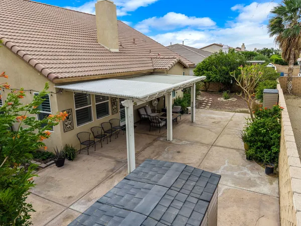 a patio with table and chairs and potted plants