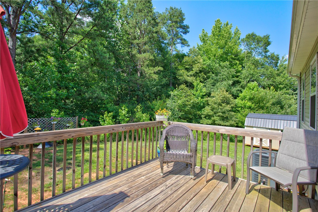 405 Pawnee Drive Walhalla, SC 29691 - Photo 4 of 36 A spacious wooden deck provides ample room for outdoor relaxation, offering a verdant view of surrounding trees.