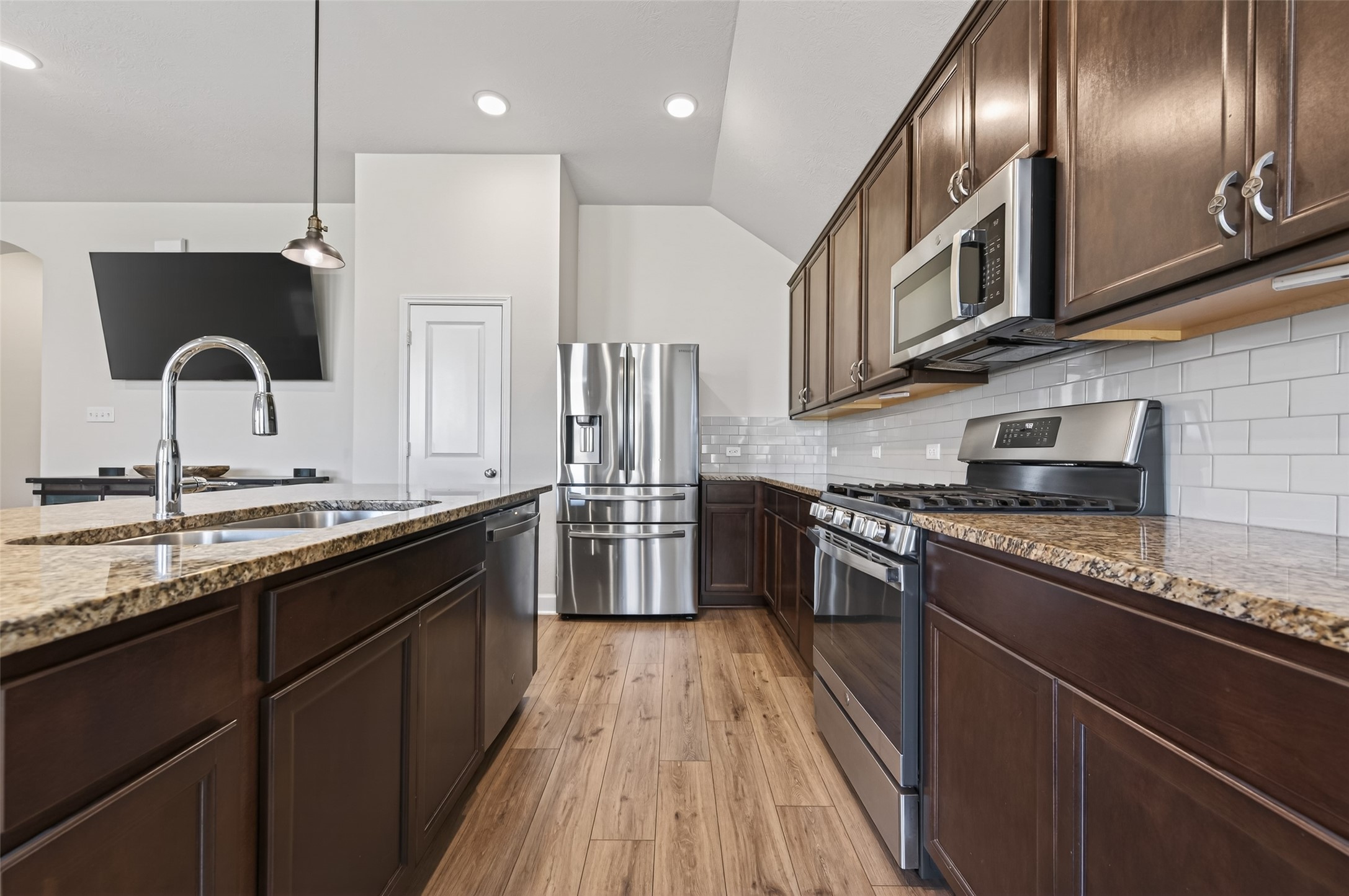 917 Farm Path Brenham, TX 77833 - Photo 17 of 43 a kitchen with stainless steel appliances granite countertop a sink a stove and a wooden floors