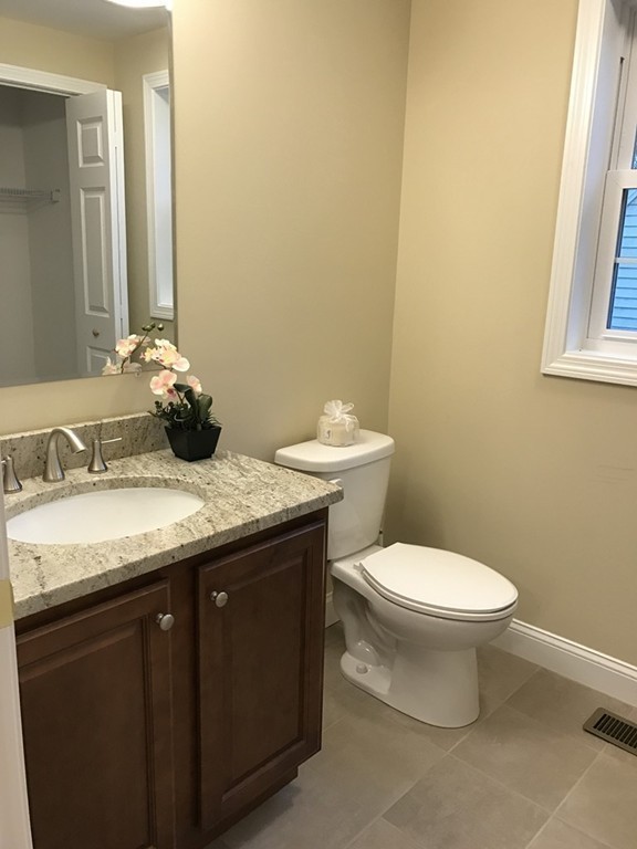 9 Reardon Road Billerica, MA 01821 - Photo 6 of 12 a bathroom with a granite countertop toilet a sink and a mirror