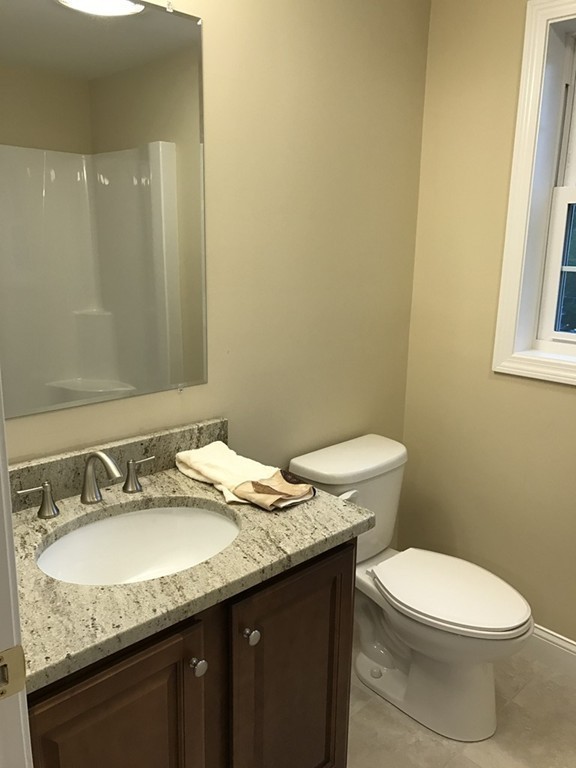 9 Reardon Road Billerica, MA 01821 - Photo 8 of 12 a bathroom with a granite countertop sink a toilet and a mirror