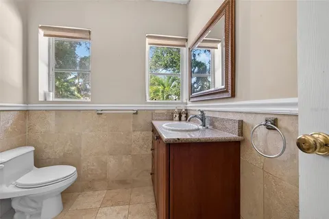 a bathroom with a granite countertop sink and a toilet