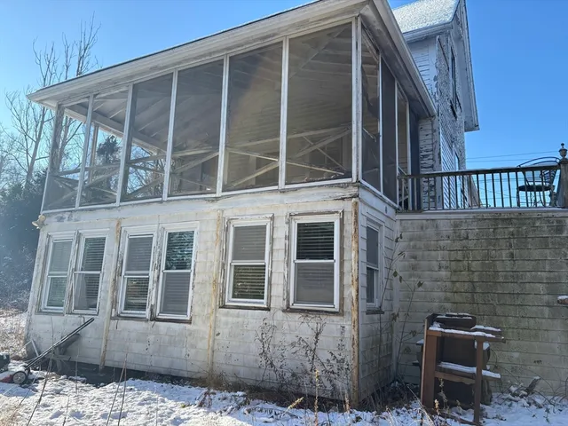 a view of a house with a door and wooden bench