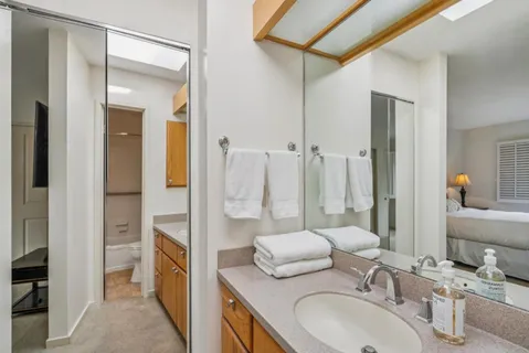 a en suite bathroom with a granite countertop sink and a mirror