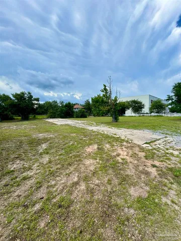 a view of a field with an trees in the background