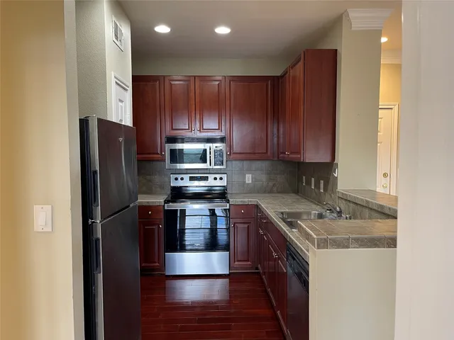 a kitchen with stainless steel appliances granite countertop a stove a refrigerator and a sink