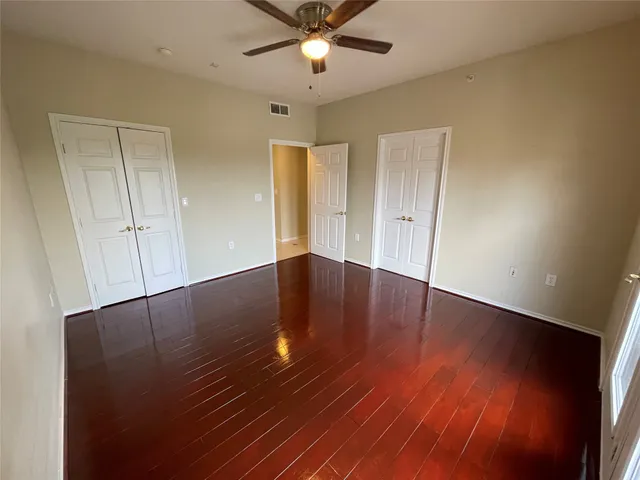 a view of a livingroom with a ceiling fan wooden floor and window