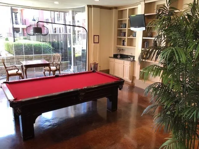 a room with pool table and windows