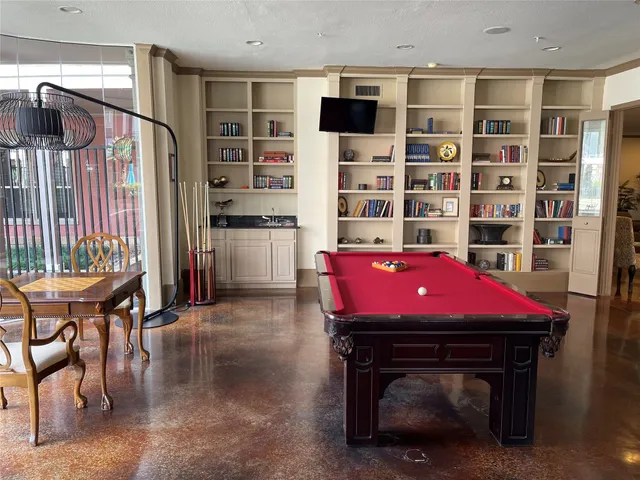 a room with a bookshelf a table and chairs