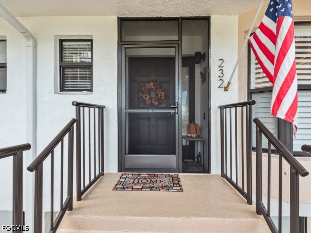 232 La Peninsula Boulevard, Unit 232 Naples, FL 34113 - Photo 3 of 44 a view of a hallway with wooden floor and windows