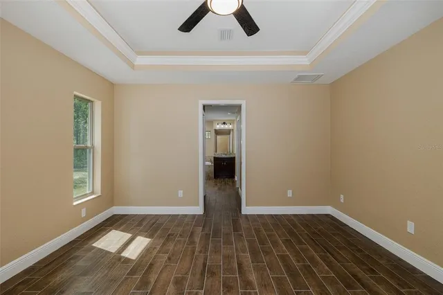 an empty room with a window and a fan