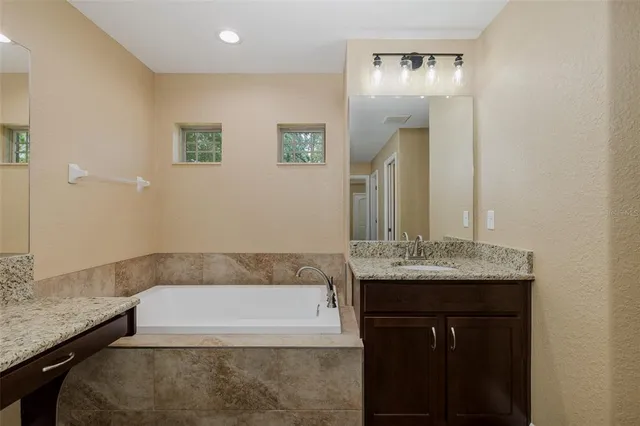 a bathroom with a granite countertop sink a toilet and a mirror