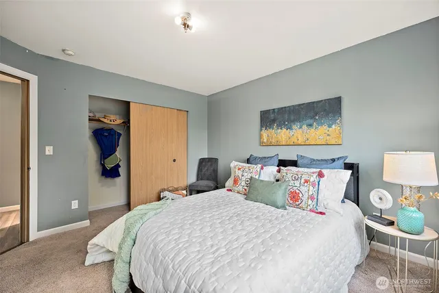 a bedroom with a bed and a painting on the wall