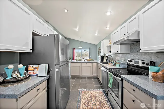 a kitchen with stainless steel appliances granite countertop a sink stove and refrigerator
