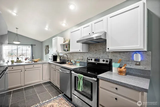 a kitchen with stainless steel appliances granite countertop a sink and cabinets