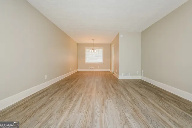 a view of a room with wooden floor and window