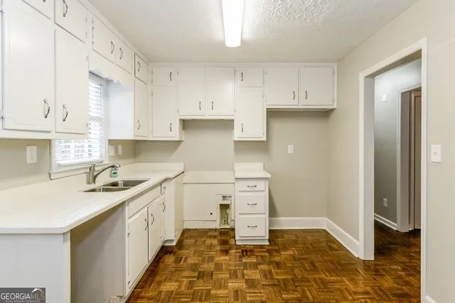 a kitchen with a sink a stove and cabinets