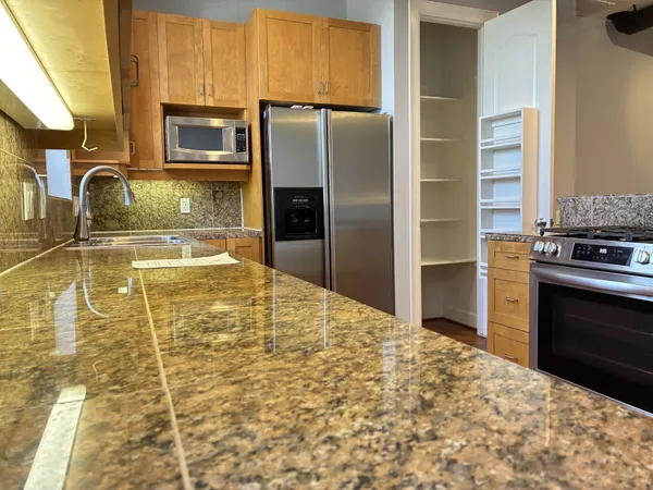 a kitchen with granite countertop a oven and a refrigerator