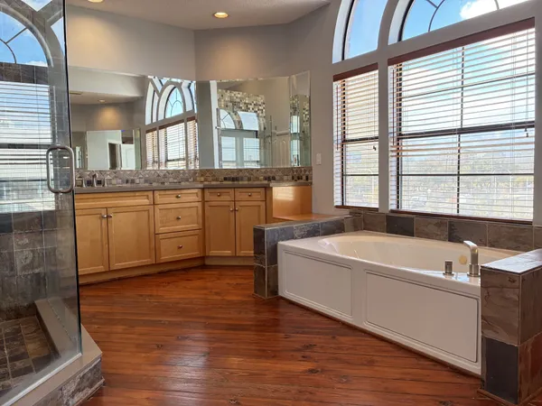 a spacious bathroom with a granite countertop tub sink and mirror