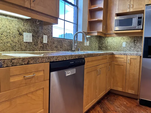 a kitchen with granite countertop stainless steel appliances and wooden cabinets