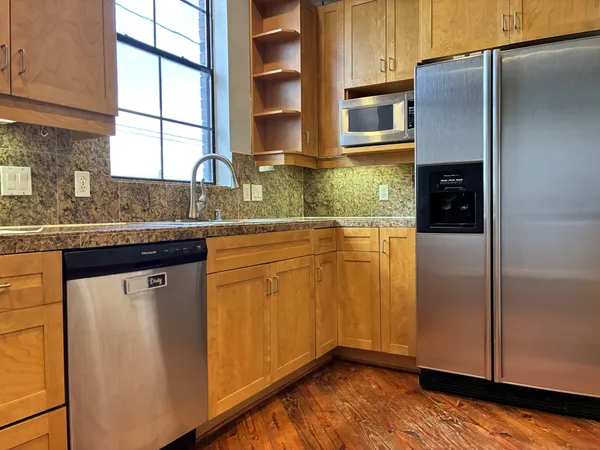 a kitchen with stainless steel appliances granite countertop a refrigerator and a sink