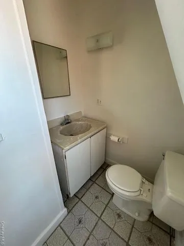 a white toilet sitting next to a sink and vanity