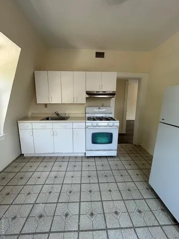 a kitchen with stainless steel appliances a sink stove and cabinets