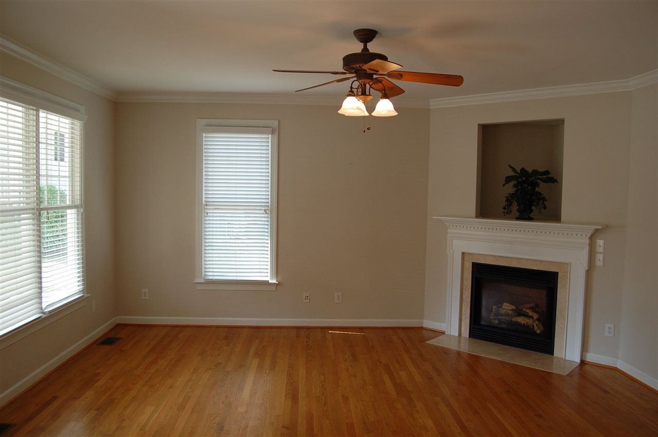 840 Nowell Ridge Road Raleigh, NC 27607 - Photo 3 of 25 Living Room w/hardwoods, 3 windows w/2” faux wood Plantation blinds, Fireplace w/marble hearth & surround, custom white wood mantle, 1 wall switch to turn on & 1 wall switch for blower, 5 blade ceiling fan w/3 lights & crown molding! Living Room