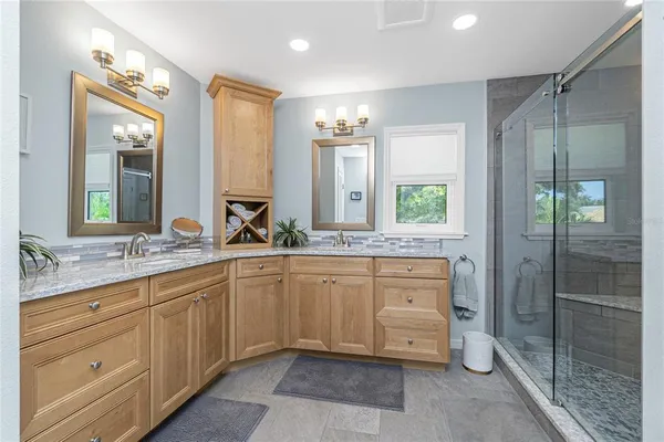 a spacious bathroom with a granite countertop sink mirror and shower