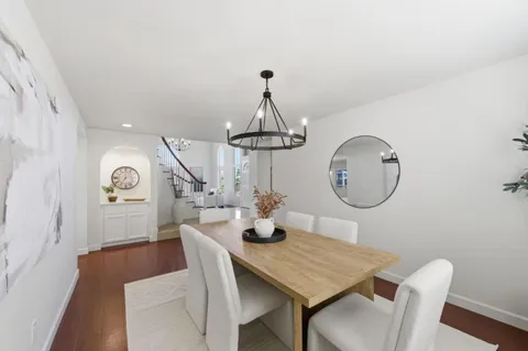 a view of a dining room with furniture a chandelier and wooden floor