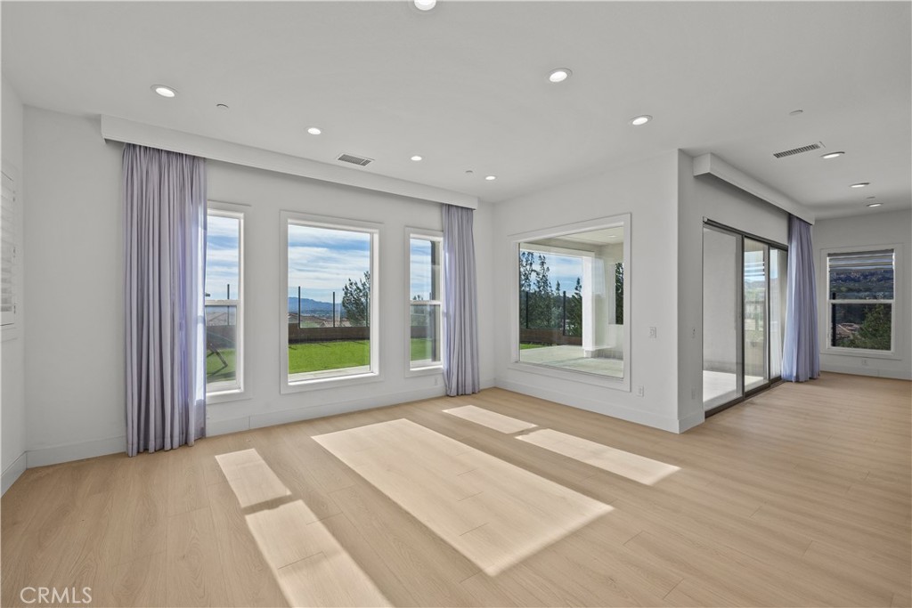 20638 Deer Grass Court Porter Ranch, CA 91326 - Photo 19 of 50 a view of an empty room with window and wooden floor