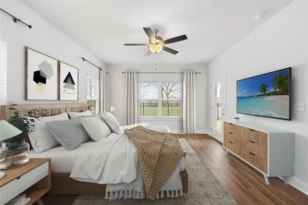 a spacious bedroom with a bed and a flat screen tv