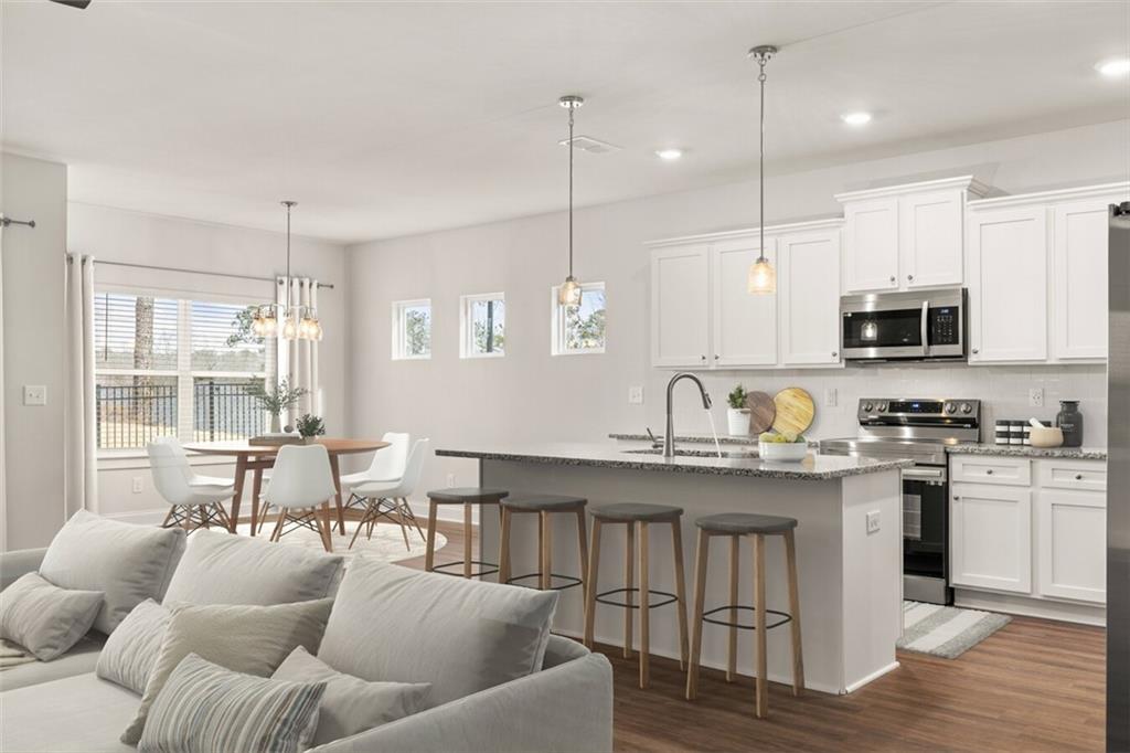 100 Agee Lane, Unit WILMONT McDonough, GA 30253 - Photo 9 of 38 a open kitchen with stainless steel appliances granite countertop a stove a sink a center island a dining table and chairs