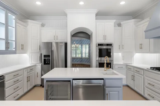 a kitchen with kitchen island a sink stainless steel appliances and cabinets