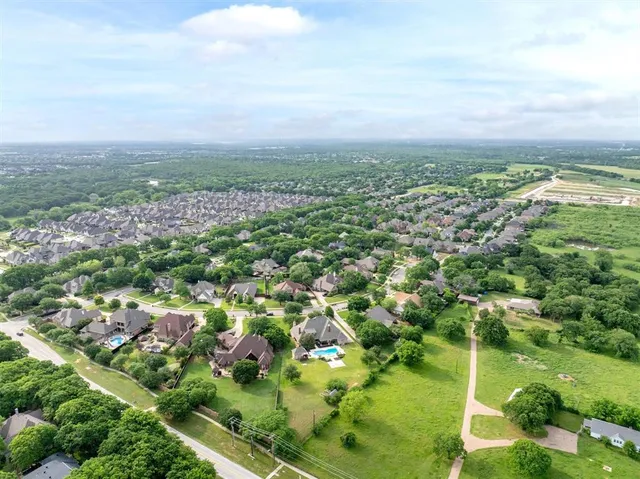 an aerial view of residential houses with outdoor space and trees