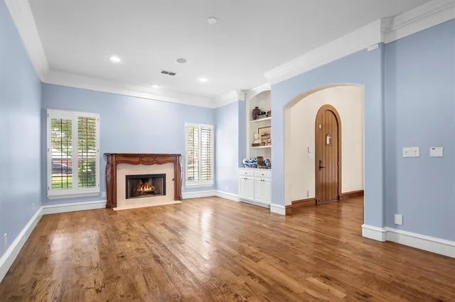 a view of empty room with wooden floor and fireplace