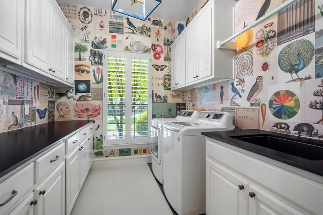 a kitchen with a sink dishwasher stove and white cabinets with wooden floor