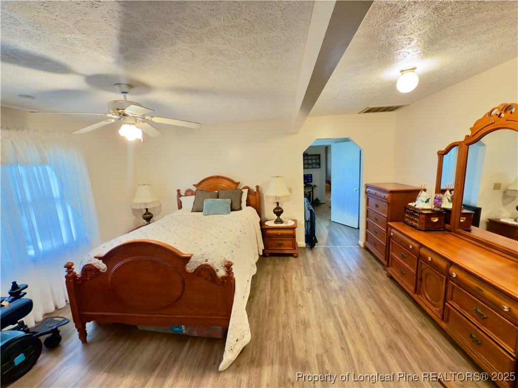 4506 Tobacco Road Orrum, NC 28369 - Photo 17 of 46 a bedroom with a bed and wooden floor