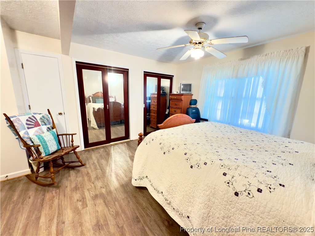 4506 Tobacco Road Orrum, NC 28369 - Photo 18 of 46 a view of a bedroom with wooden floor and ceiling fan