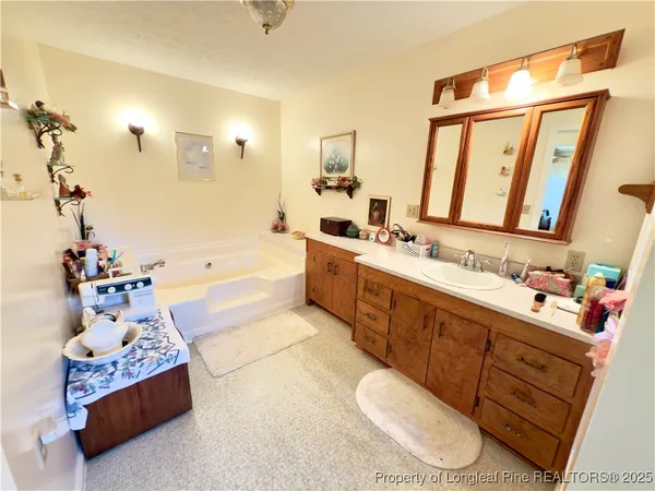 a spacious bathroom with a double vanity sink toilet and a tub