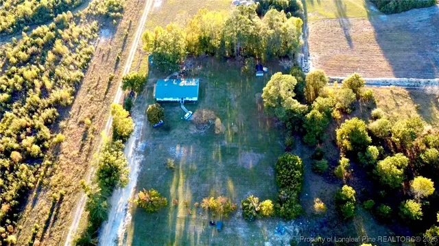 a view of a house with a big yard and large trees