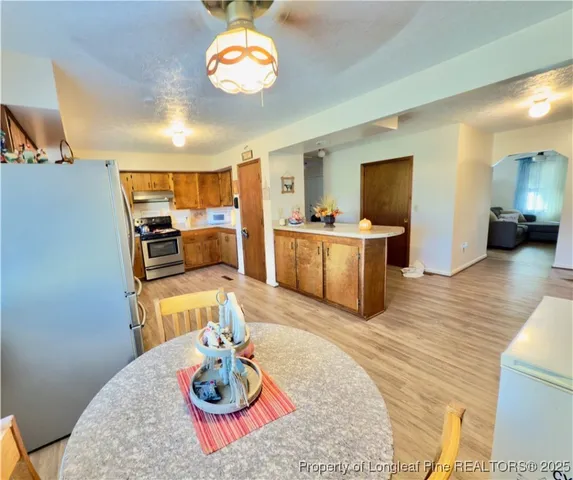 a kitchen with stainless steel appliances kitchen island granite countertop a sink cabinets and wooden floor